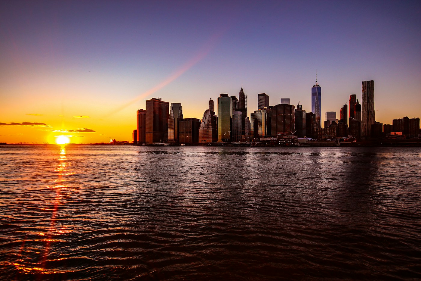 New York City skyline glowing at sunset across the waterfront